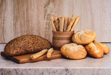 Çörekli çıtır ekmek. Fransız ekmeği. Taze taze ekmek. Ekmek arkaplanı. Ahşap arka planda farklı cins..