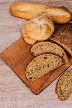 Çörekli çıtır ekmek. Fransız ekmeği. Taze taze ekmek. Ekmek arkaplanı. Ahşap arka planda farklı cins..