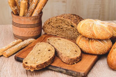 Çörekli çıtır ekmek. Fransız ekmeği. Taze taze ekmek. Ekmek arkaplanı. Ahşap arka planda farklı cins..