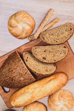 Çörekli çıtır ekmek. Fransız ekmeği. Taze taze ekmek. Ekmek arkaplanı. Ahşap arka planda farklı cins..