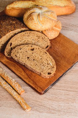 Çörekli çıtır ekmek. Fransız ekmeği. Taze taze ekmek. Ekmek arkaplanı. Ahşap arka planda farklı cins..