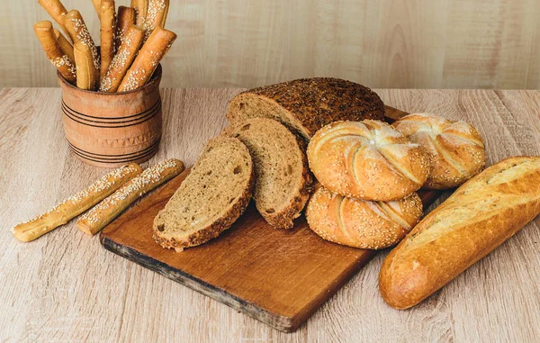 Çörekli çıtır ekmek. Fransız ekmeği. Taze taze ekmek. Ekmek arkaplanı. Ahşap arka planda farklı cins..