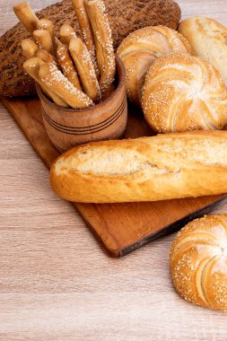 Çörekli çıtır ekmek. Fransız ekmeği. Taze taze ekmek. Ekmek arkaplanı. Ahşap arka planda farklı cins..