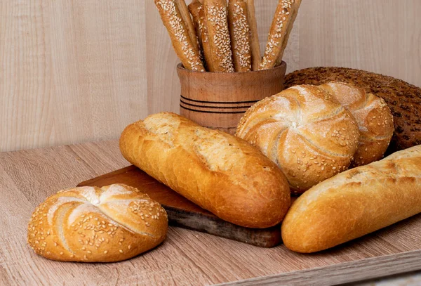 Crisp bread with buns. French baguettes. Fresh crispbread. Bread background. Different breed  on wooden background.