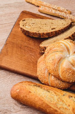 Çörekli çıtır ekmek. Fransız ekmeği. Taze taze ekmek. Ekmek arkaplanı. Ahşap arka planda farklı cins..
