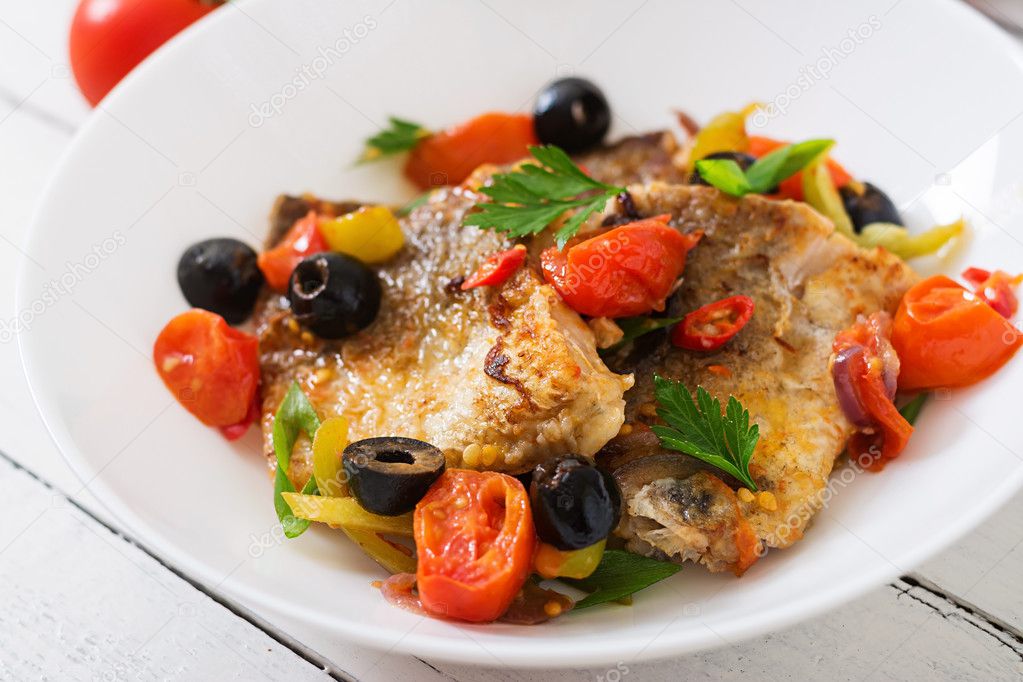 Fried hake fillet with tomato and olives
