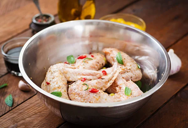 Alitas de pollo marinadas crudas en un tazón —  Fotos de Stock