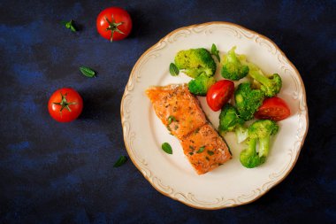 Brokoli ve domates ile süslenmiş pişmiş somon