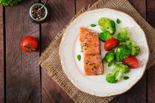 Baked salmon garnished with broccoli and tomatoes — Stock Photo, Image