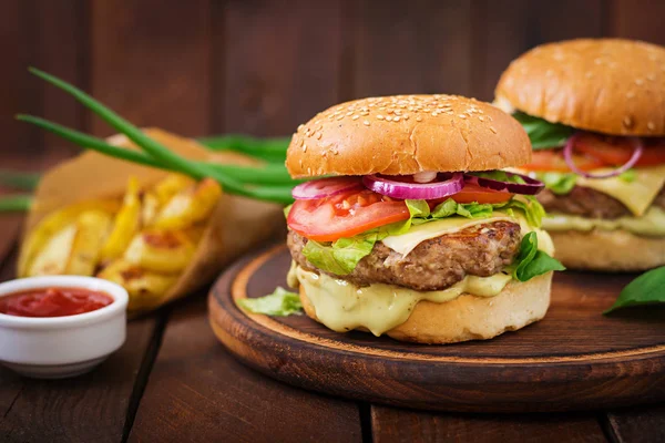 Hovězí hamburgery na dřevěné desce — Stock fotografie