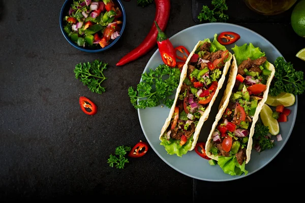 beef tacos with tomato sauce and salsa