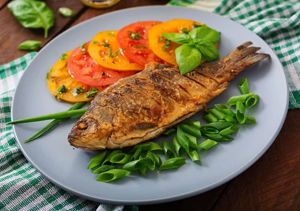 Carpa de pescado frito y tomates en rodajas — Foto de Stock