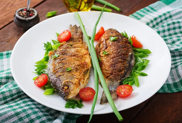 Fried fish carp and sliced tomatoes — Stock Photo, Image