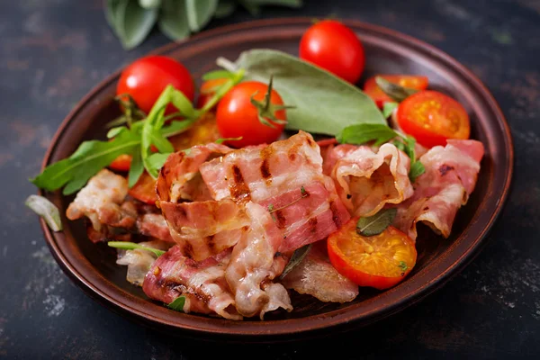 Bacon frito e tomates em prato — Fotografia de Stock