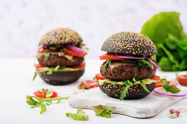 beyaz kesme tahtası üzerinde siyah hamburger