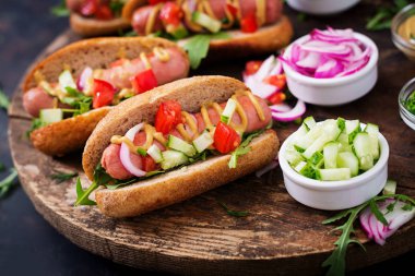 Sosisli sandviç salatalık, domates ve soğan ile