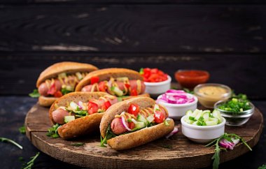 Sosisli sandviç salatalık, domates ve soğan ile