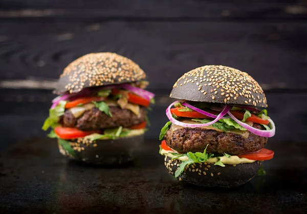 Hamburger neri su sfondo nero — Foto Stock