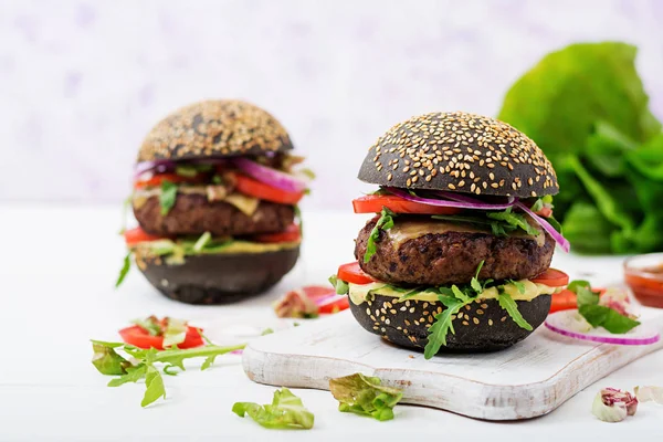 beyaz kesme tahtası üzerinde siyah hamburger
