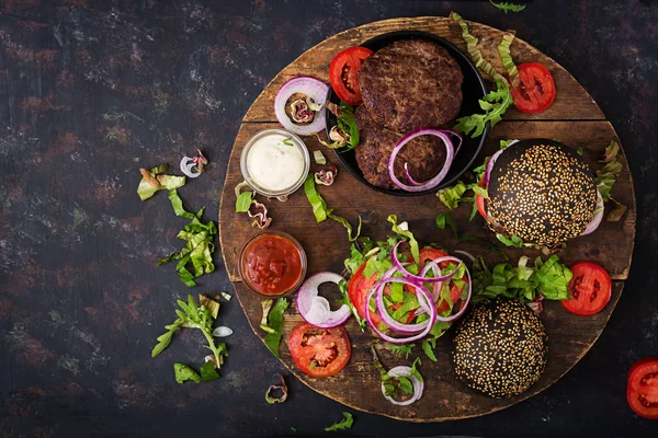 Hamburgers noirs sur planche à découper — Photo