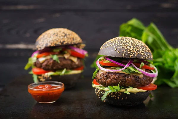 Hamburger neri su sfondo nero — Foto Stock