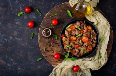 Chicken liver with tomatoes in frying pan  clipart