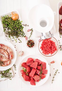 doğranmış çiğ et ve ev yapımı sosis kıyma masada, forcemeat hazırlama işlemi kavramı ile plakalar  