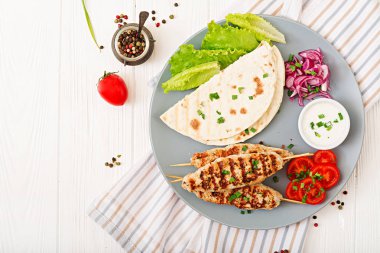 Türkiye'de plaka üzerinde taze sebze ile kıyılmış Lula kebap ızgara 