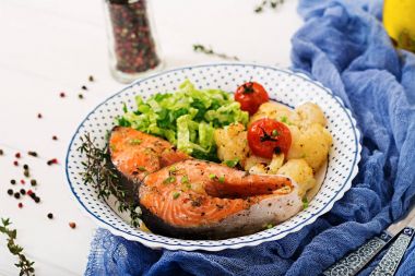 Diyet menüsü. Karnabahar, domates ve otlar pişmiş somon steak. Doğru beslenme. Sağlıklı yaşam tarzı