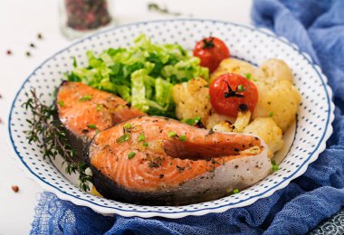 Diyet menüsü. Karnabahar, domates ve otlar pişmiş somon steak. Doğru beslenme. Sağlıklı yaşam tarzı