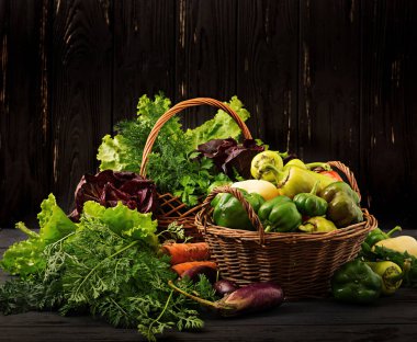 Assortment of vegetables and green herbs. Market. Vegetables in a basket on a dark background clipart