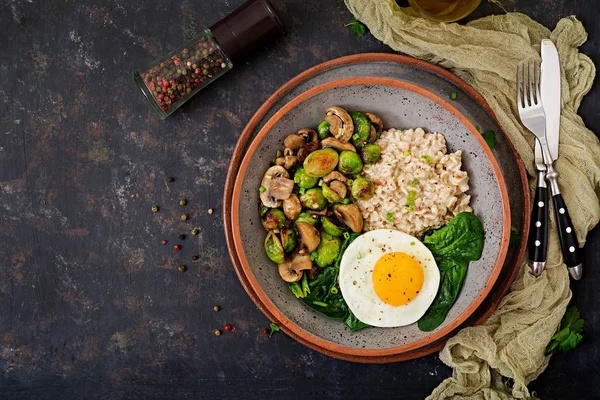 Sağlıklı kahvaltı. Yulaf lapası, yumurta ve pişmiş sebze - mantar ve Brüksel lahanası salatası. Sağlıklı bir yaşam tarzı. Üstten Görünüm