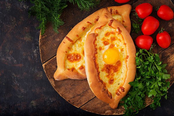 Khachapuri in Adjarian. Open pies with mozzarella and egsg. Georgian cuisine.
