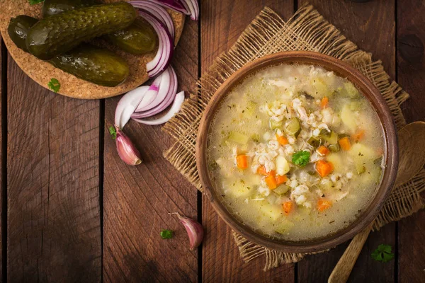 Soup with pickled cucumbers and pearl barley - rassolnik on a wooden background. Top view. — Stock Image Soup Pickled Cucumbers Pearl Barley Rassolnik Wooden Background Top View Stock Picture