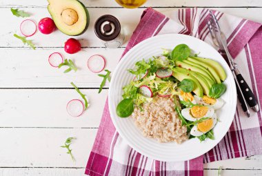 Sağlıklı kahvaltı. Diyet menüsü. Yulaf lapası ve avokado salata ve yumurtaları. Üstten Görünüm