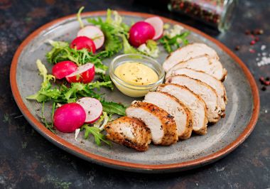 Fırında tavuk göğsü ve karanlık bir arka plan üzerinde plaka üzerinde taze sebze. Doğru beslenme. Diyet menüsü.