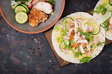 Fırında tavuk göğsü, salatalık, turp ve marul ile sağlıklı Meksika Taco. Düz yatıyordu. Üstten Görünüm