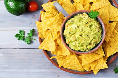 Guacamole avokado, limon, domates, soğan ve Salantro, cips ile - geleneksel Meksika aperatif servis. Düz yatıyordu. Üstten Görünüm.