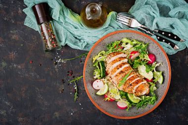 Salata taze sebze ve karanlık bir arka plan üzerinde pişmiş tavuk göğsü ile top. Doğru beslenme. Diyet menüsü. Düz yatıyordu. Üstten Görünüm