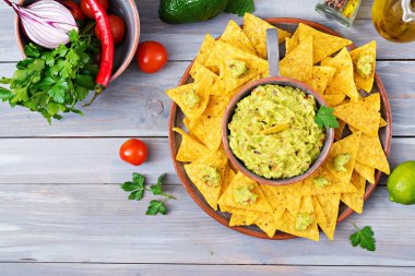 Guacamole avokado, limon, domates, soğan ve Salantro, cips ile - geleneksel Meksika aperatif servis. Düz yatıyordu. Üstten Görünüm.