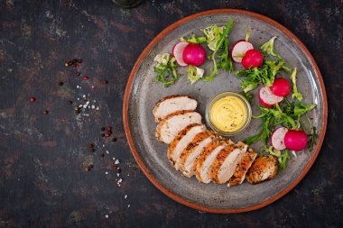 Fırında tavuk göğsü ve karanlık bir arka plan üzerinde plaka üzerinde taze sebze. Doğru beslenme. Diyet menüsü. Düz yatıyordu. Üstten Görünüm