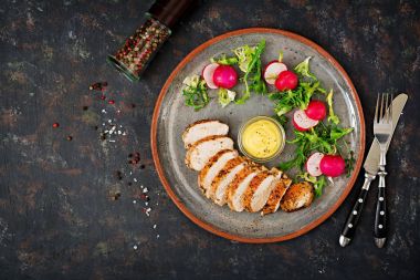 Fırında tavuk göğsü ve karanlık bir arka plan üzerinde plaka üzerinde taze sebze. Doğru beslenme. Diyet menüsü. Düz yatıyordu. Üstten Görünüm