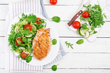 Izgara tavuk göğsü ve taze sebze salatası - domates, salatalık ve marul yaprakları. Tavuk salatası. Sağlıklı gıda. Düz yatıyordu. Üstten Görünüm