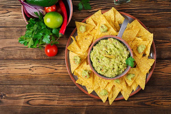 Guacamole avokado, limon, domates, soğan ve Salantro, cips ile - geleneksel Meksika aperatif servis. Düz yatıyordu. Üstten Görünüm.