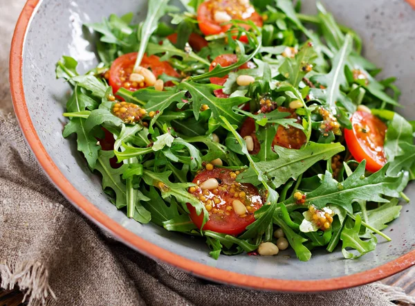 Dietary menu. Vegan cuisine. Healthy salad with arugula, tomatoes and pine nuts.