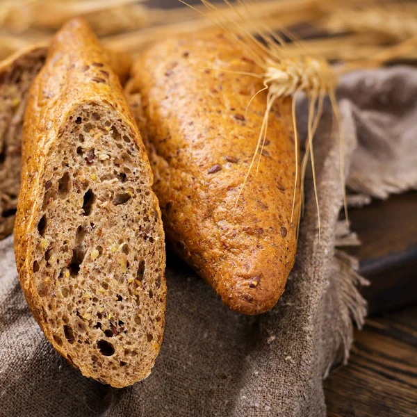 木製の背景に亜麻の種子の追加と全粒粉のパン — ストック写真