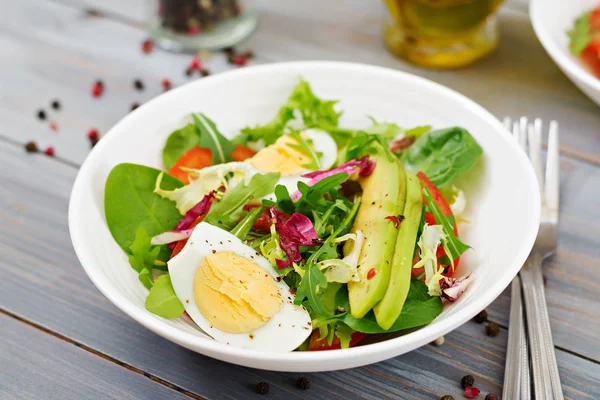Lezzetli ve hafif salata, domates, yumurta ve bir karışım marul yaprakları. Sağlıklı kahvaltı.