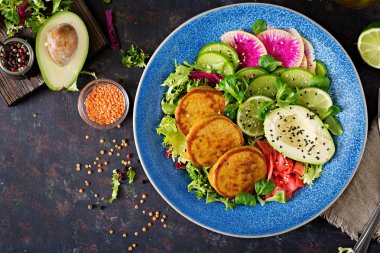 Vegan Buda kase yemek yemek masası. Sağlıklı gıda. Sağlıklı vegan yemek kase. Ziyan mercimek ve turp, Avokado salatası. Düz yatıyordu. Üstten Görünüm