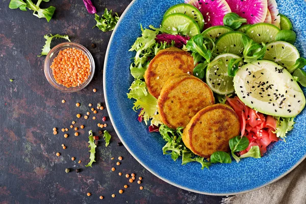 Vegan buddha bowl dinner food table. Healthy food. Healthy vegan lunch bowl. Fritter with lentils and radish, avocado salad. Flat lay. Top view