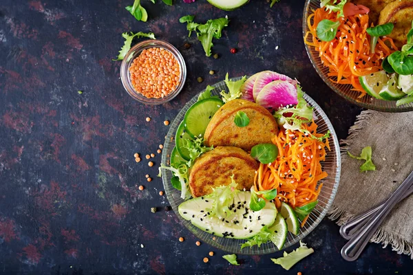 Vegan buddha bowl dinner food table. Healthy food. Healthy vegan lunch bowl. Fritter with lentils and radish, avocado, carrot salad. Flat lay. Top view